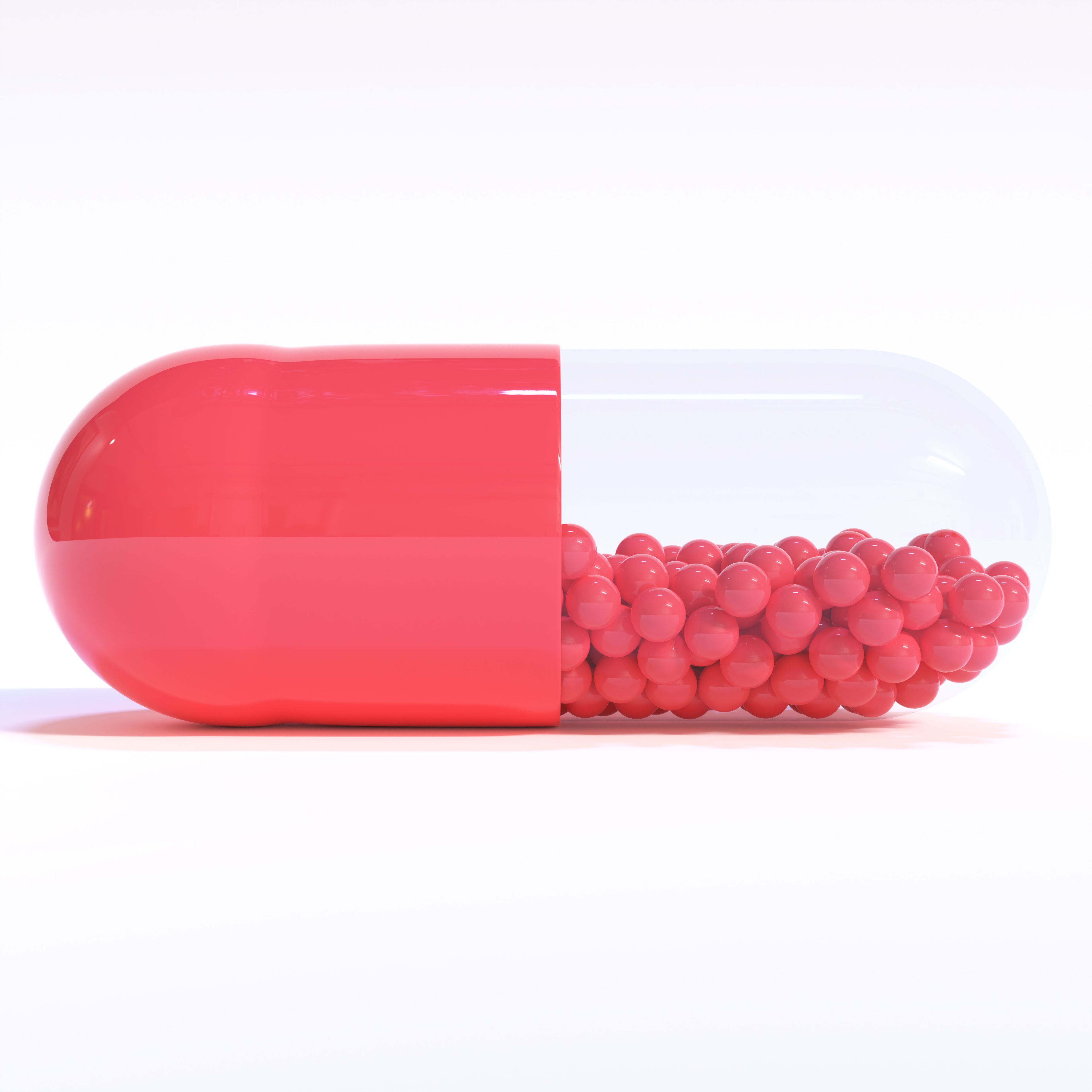 Red Capsule Full of Granules On White Background