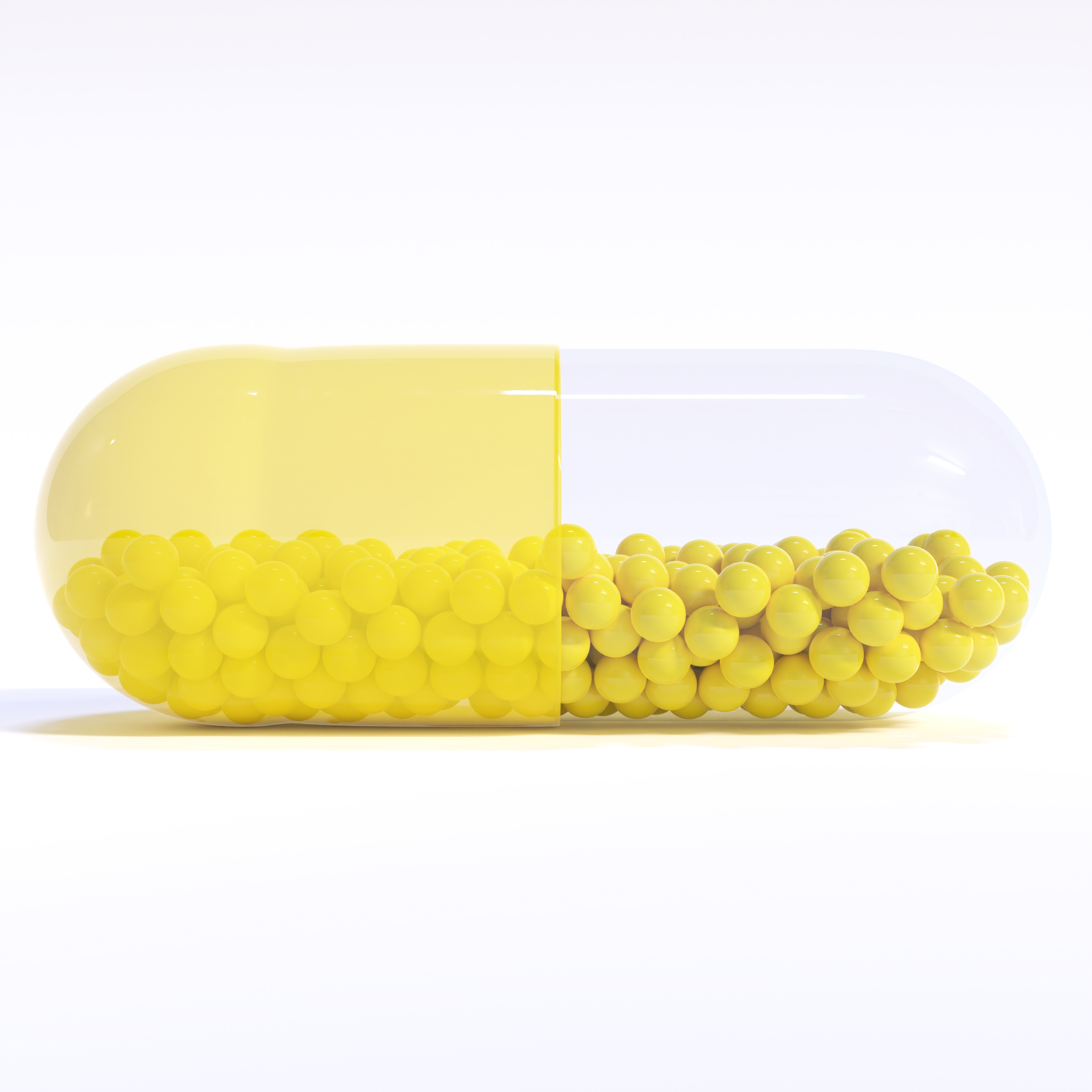 Transparent Yellow Capsule With Granules With White Background