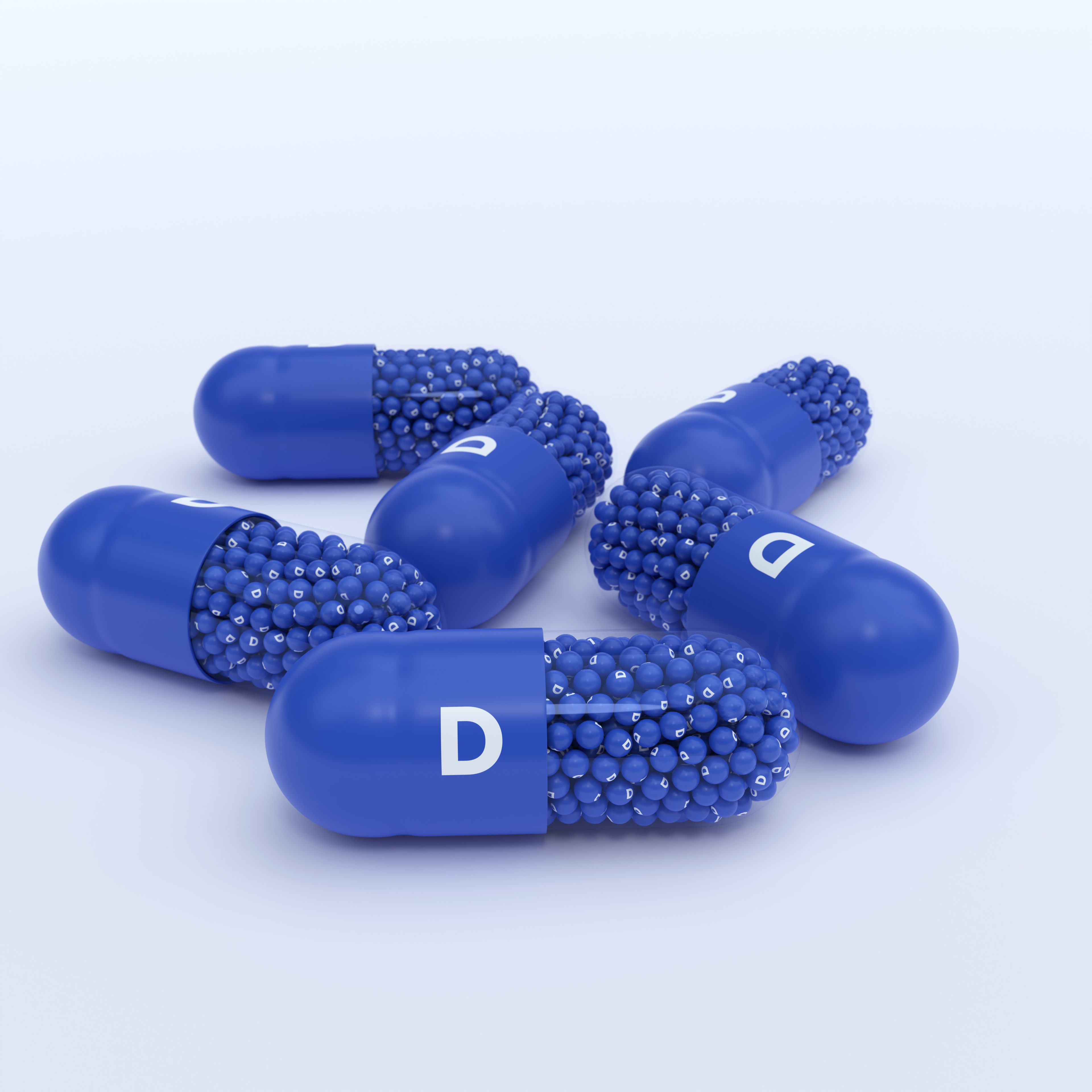 Vitamin D, Blue Capsules, Granules and Whtie Background