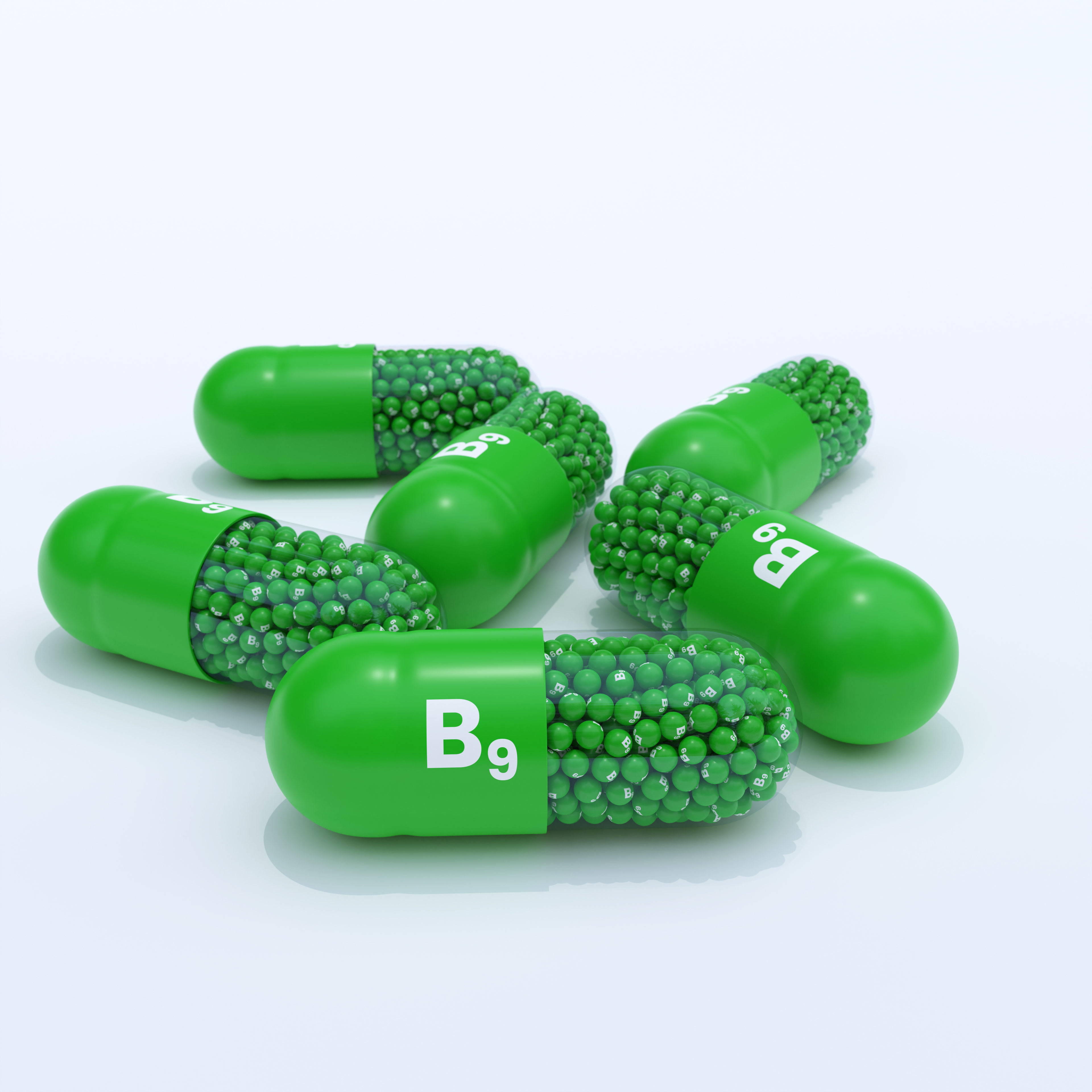 Vitamin B9 With Green Capsules, Granules and White Background