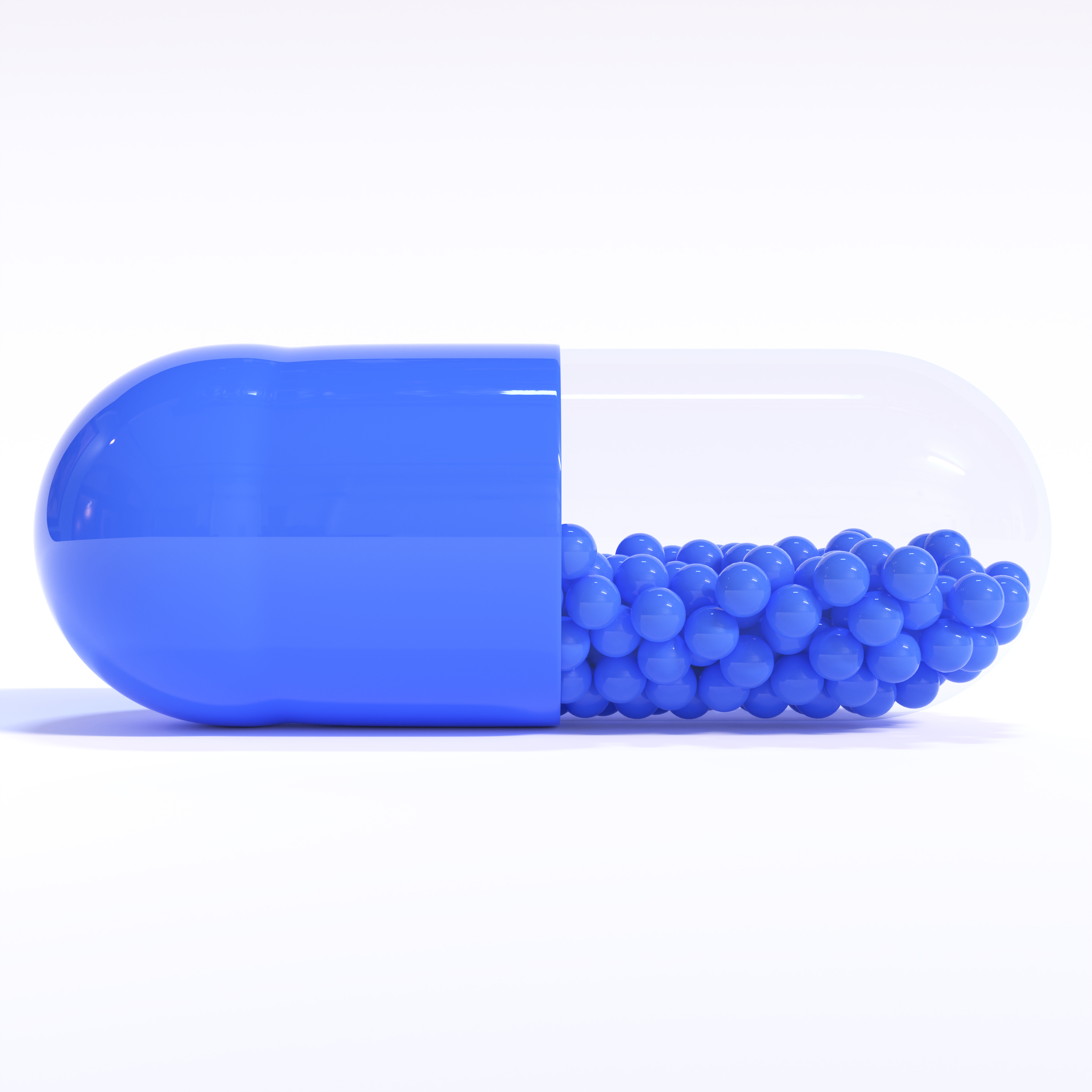 Blue Capsule Full of Granules On White Background