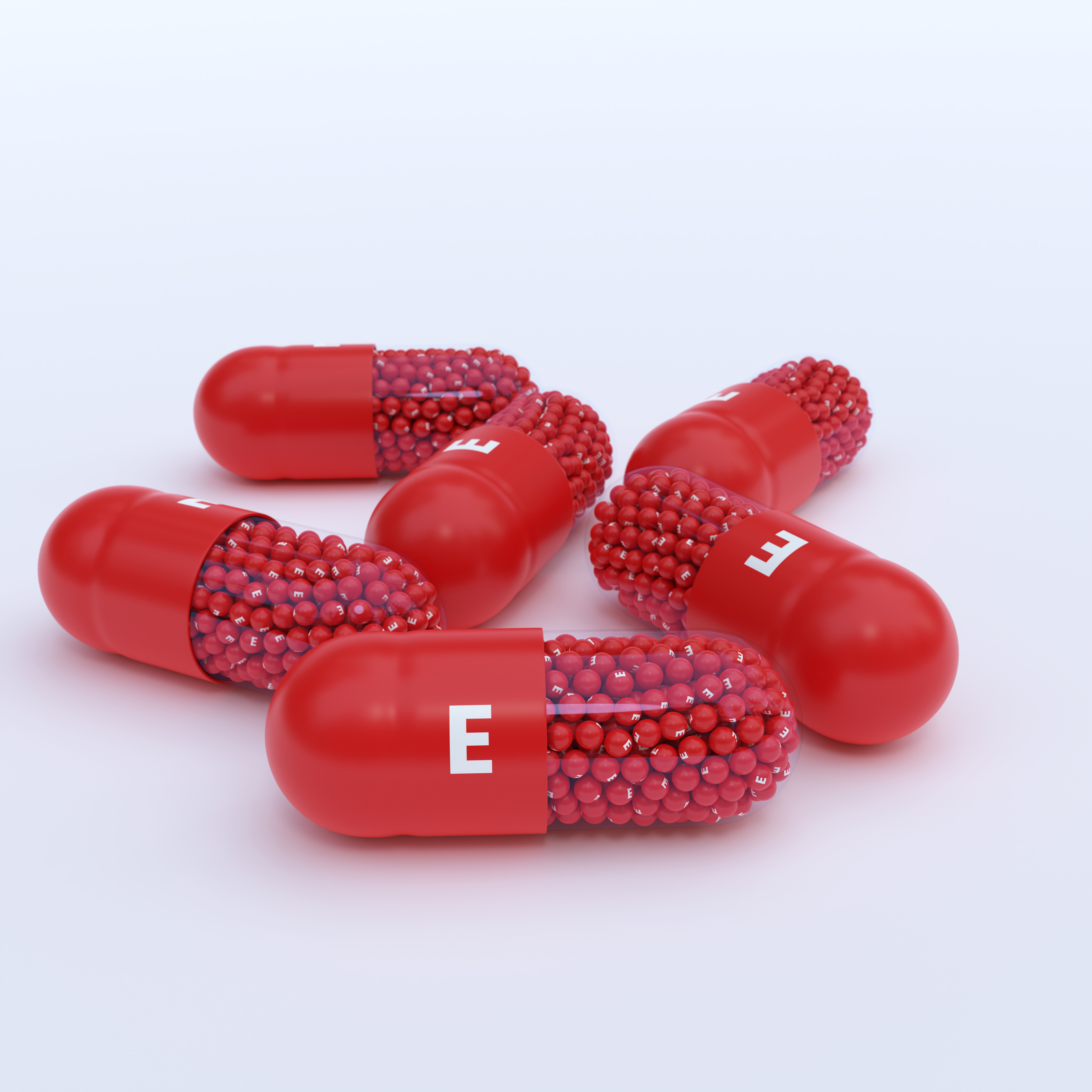 Vitamin E With Red Capsules, Granules and White Background