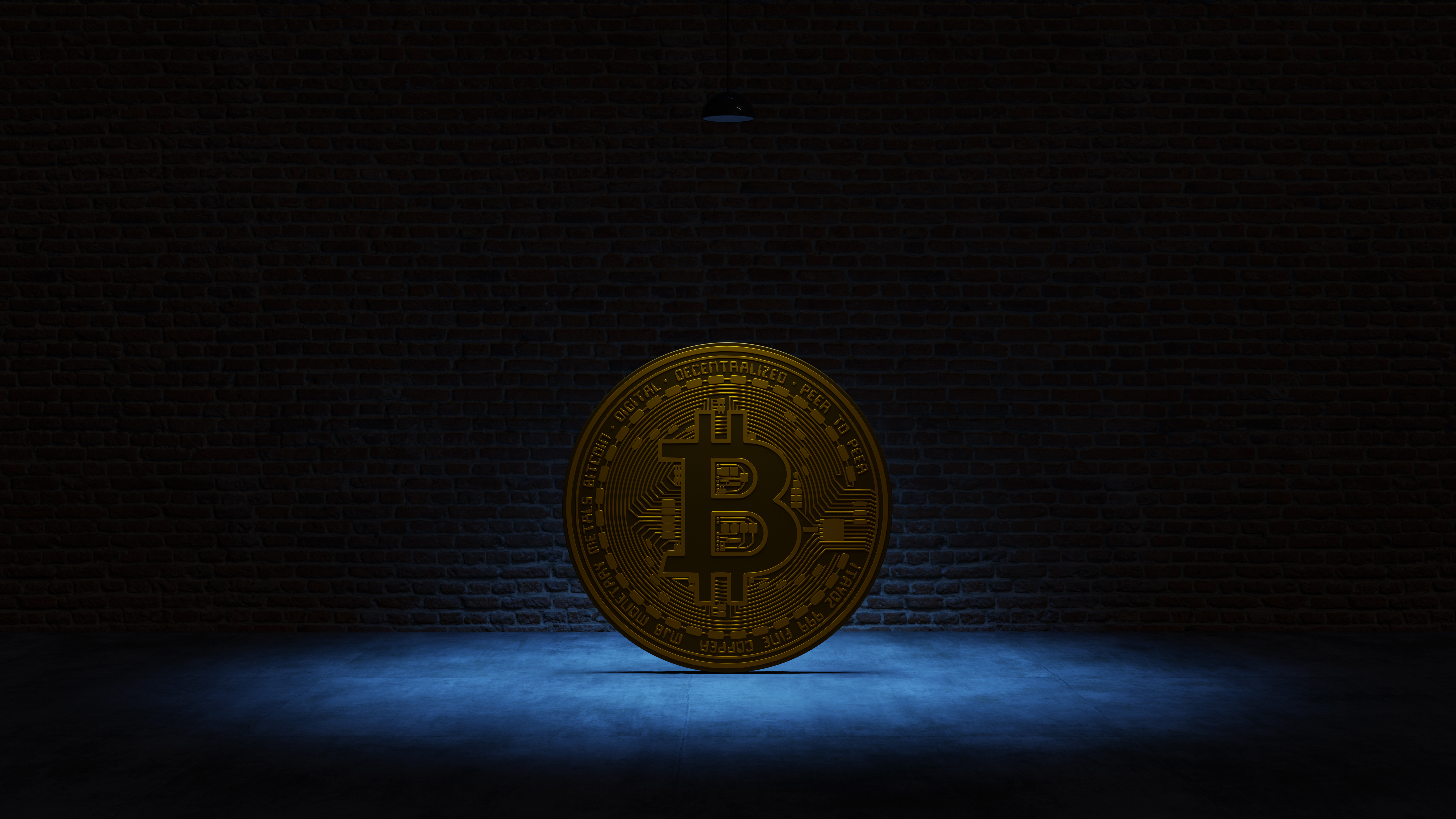 Golden Bitcoin under a blue spotlight in front of a brick wall