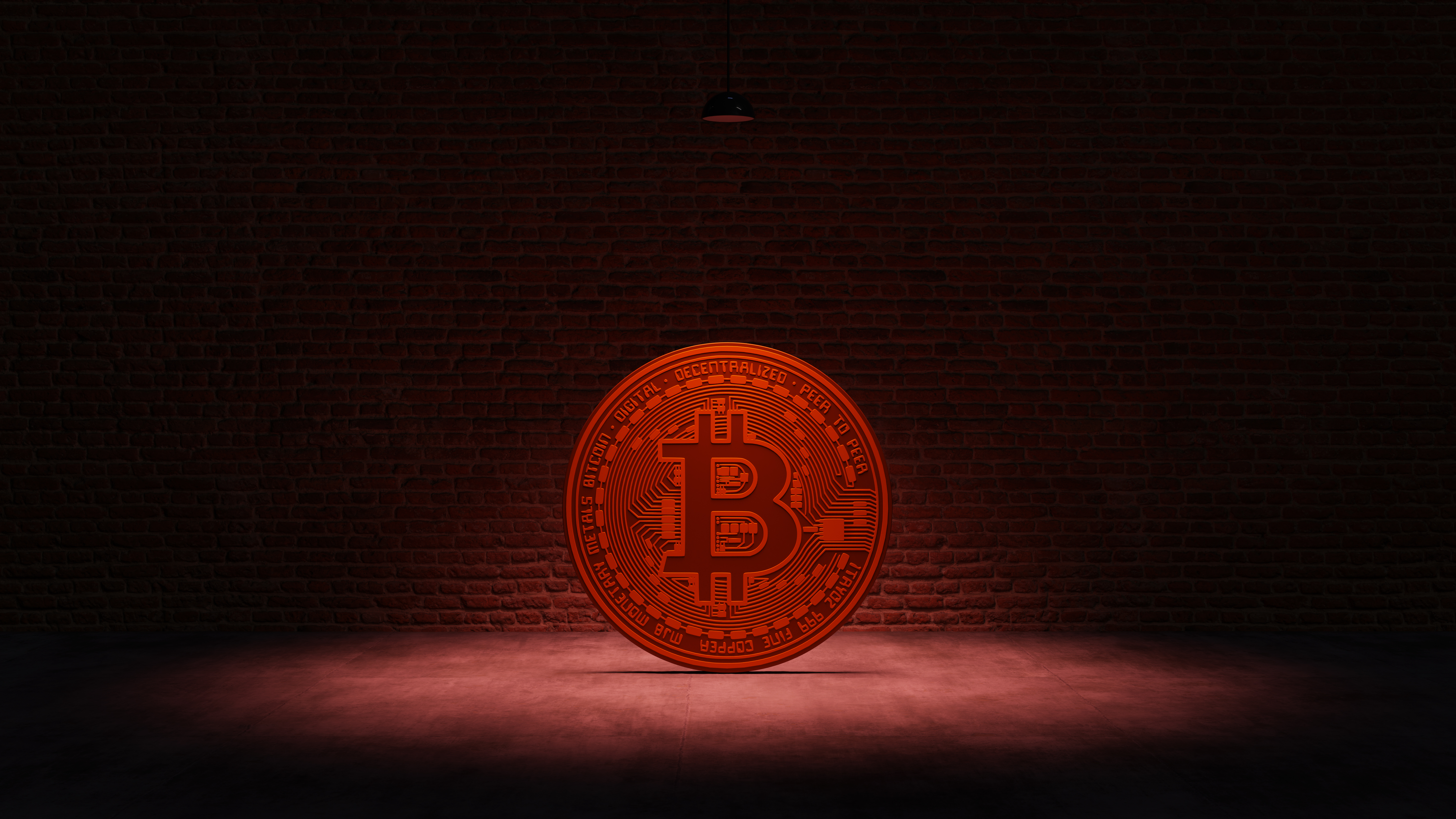 Golden Bitcoin under a red spotlight in front of a brick wall