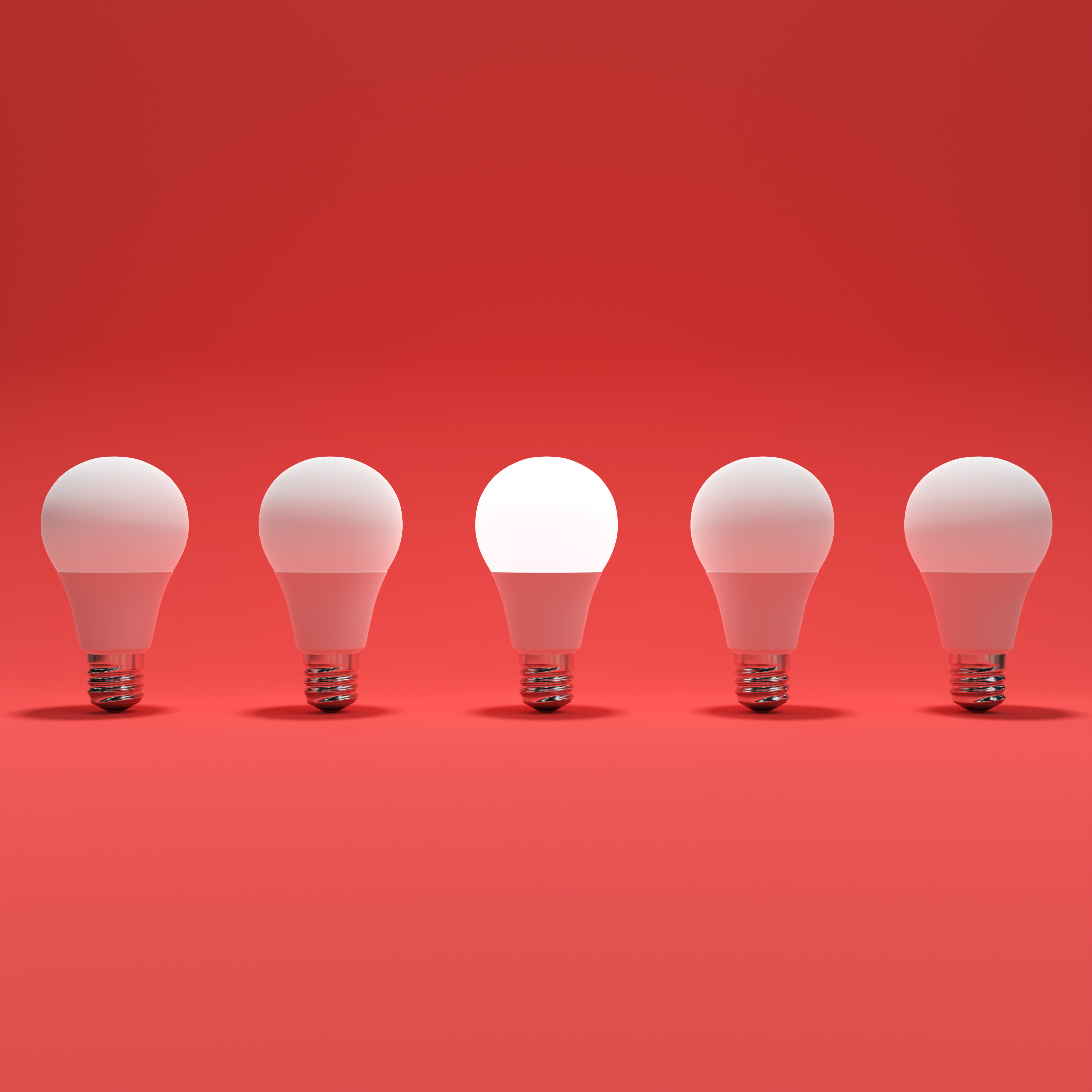 Five Lightbulb and One Glowing Lightbulb with Red Background