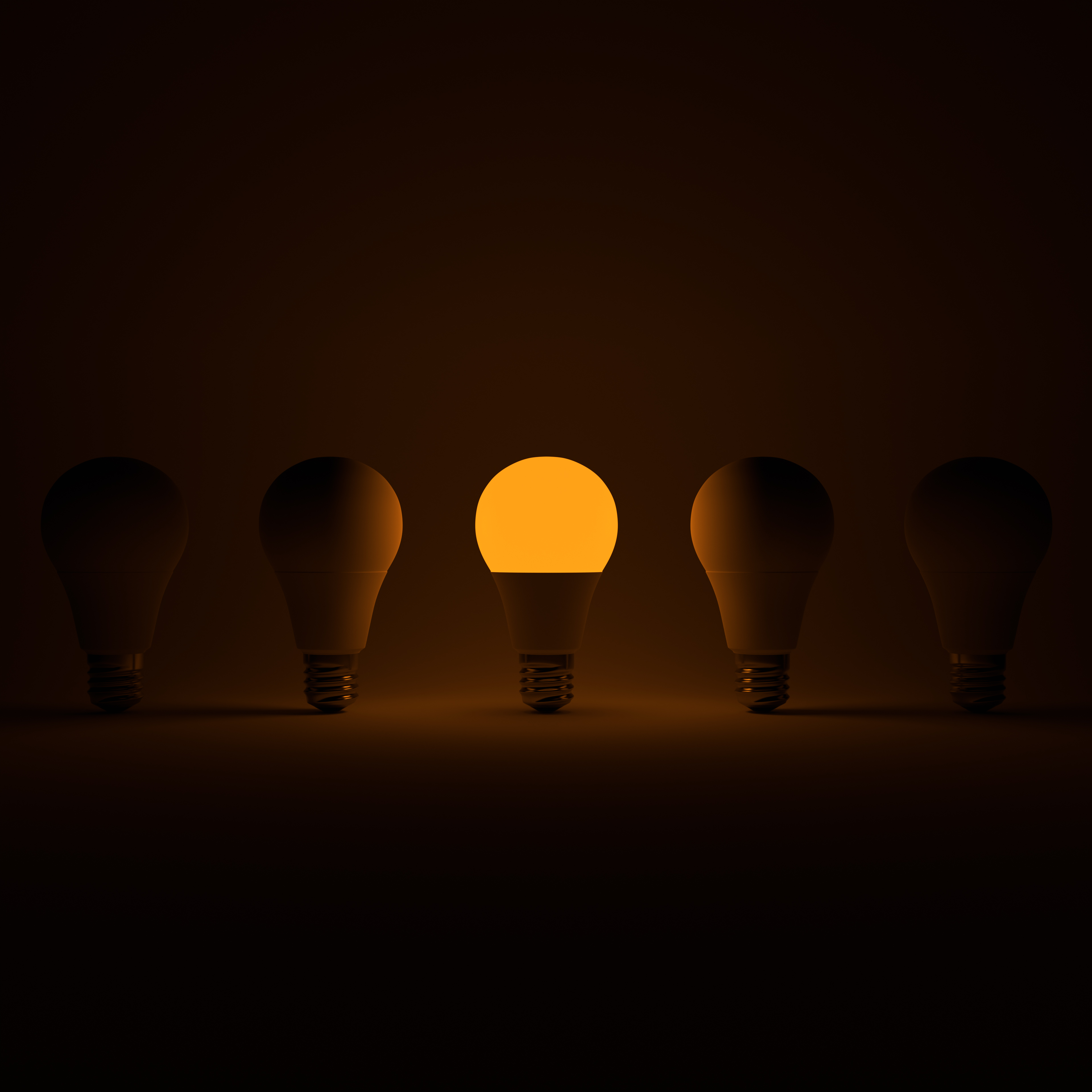 Five Lightbulb and One Glowing Orange Lightbulb with White Background