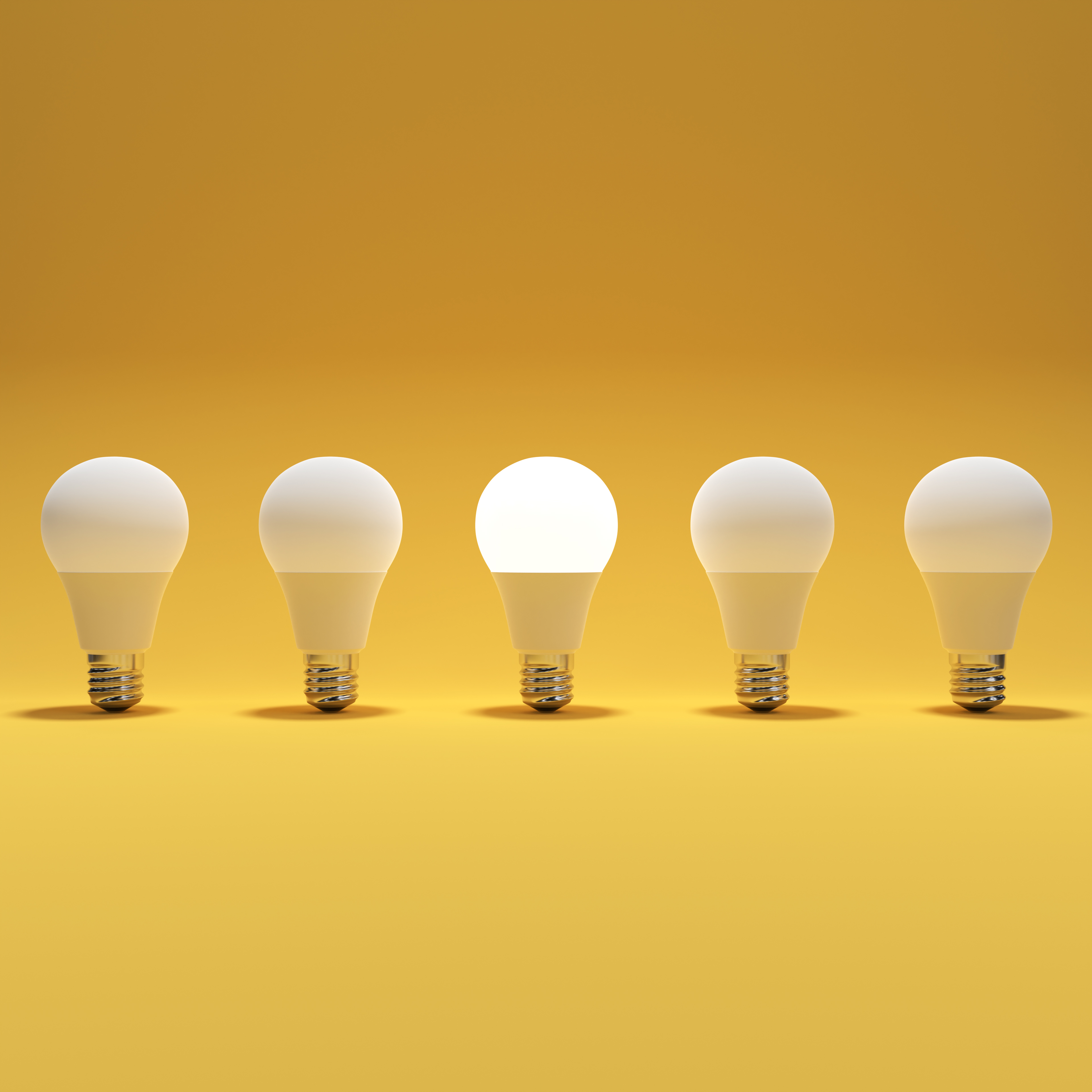 Five Lightbulb and One Glowing Lightbulb with Yellow Background