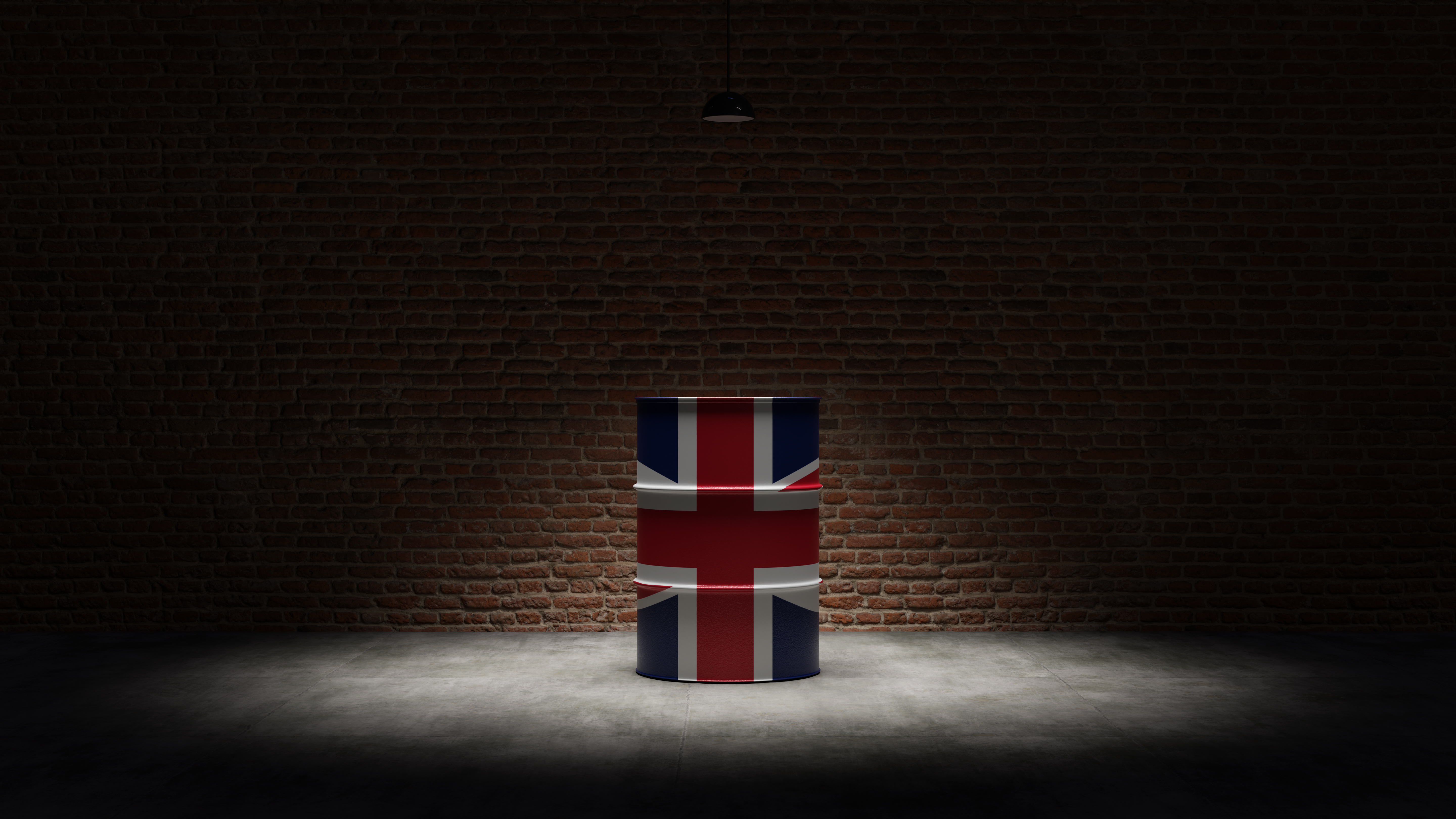 Oil barrel with the flag of United Kingdom in front of a brick background